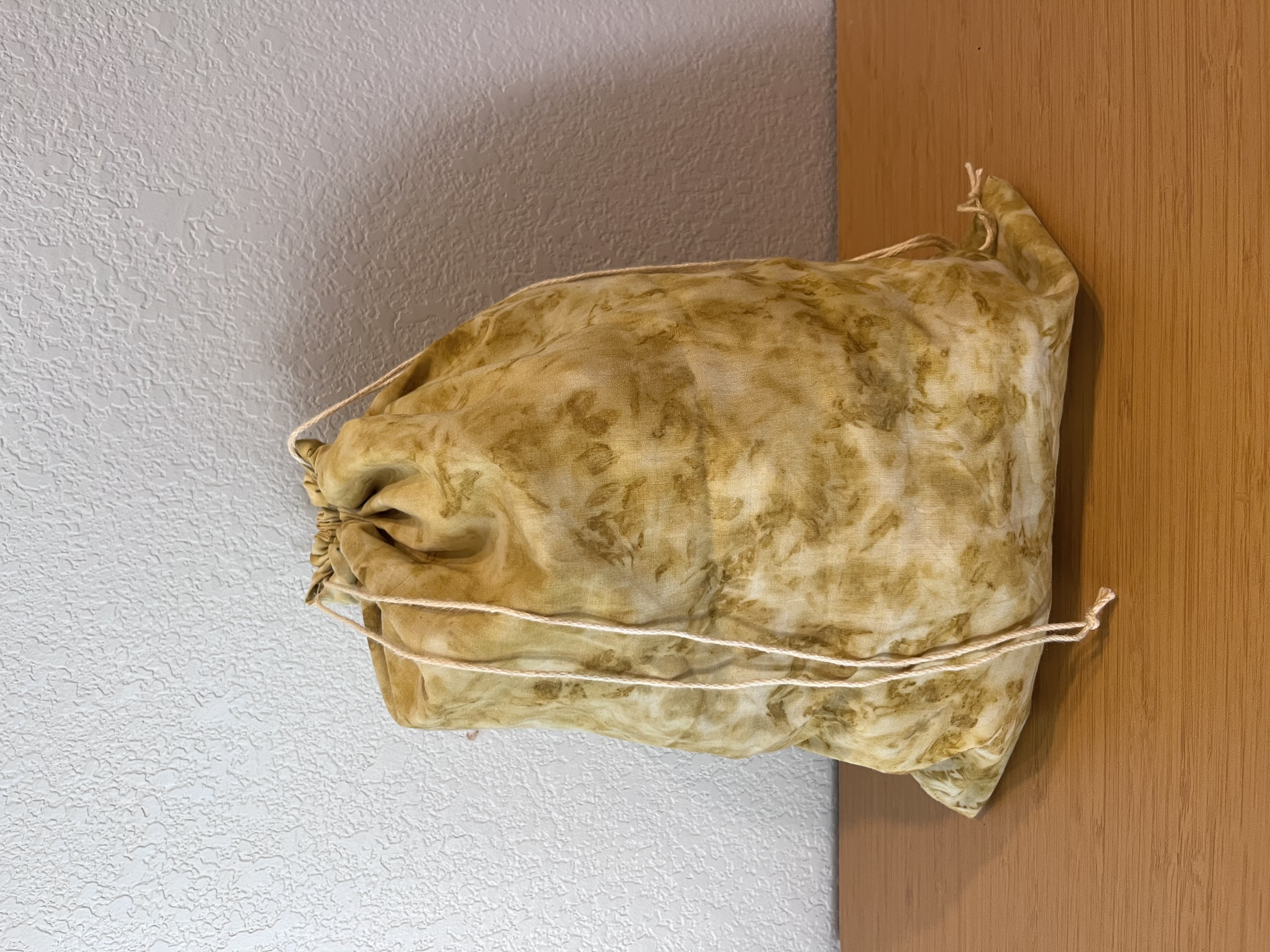 Photo of drawstring bag with marigold eco print.