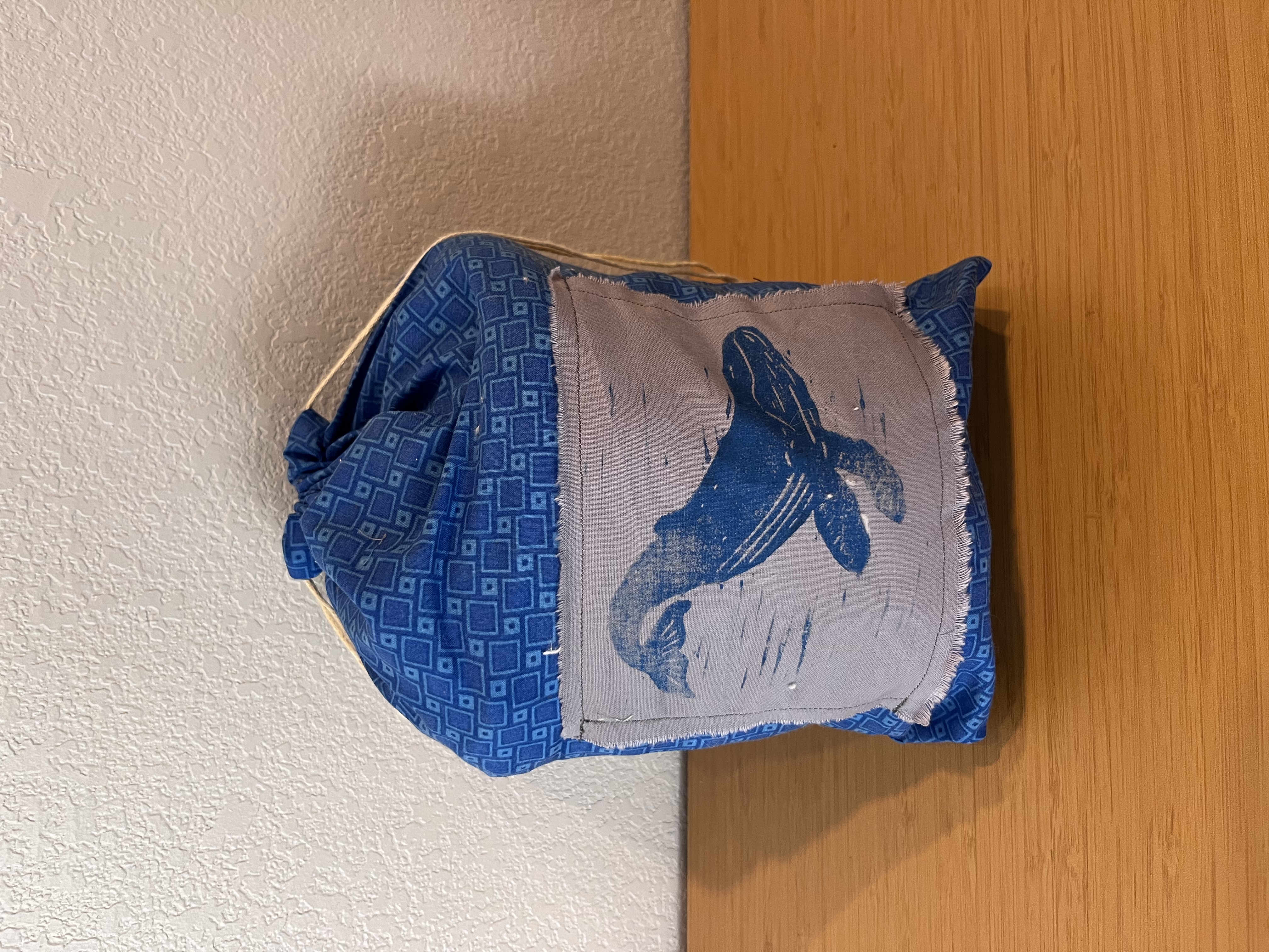 Photo of drawstring bag with blue pattern and whale patch.